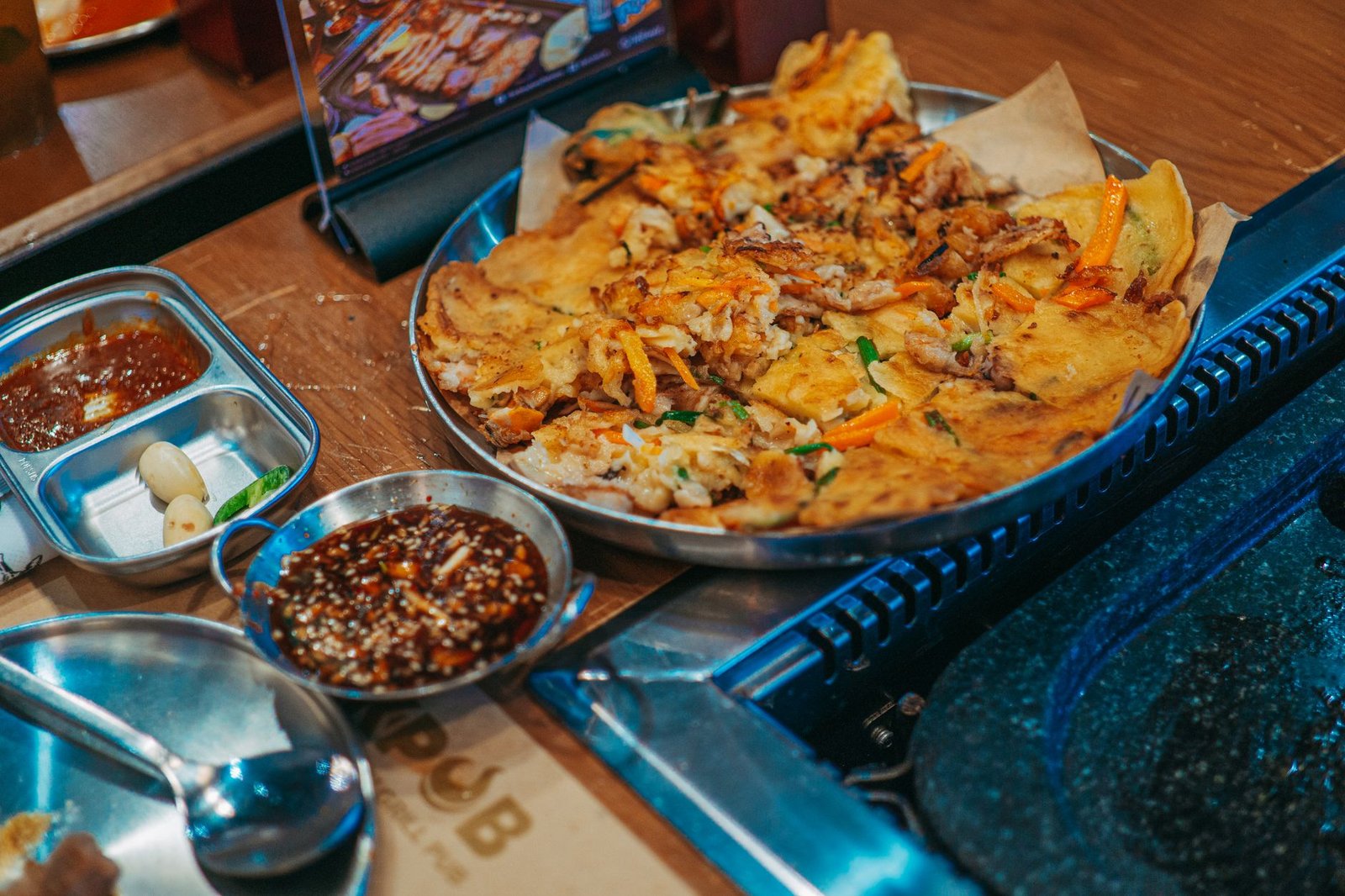 what to eat at Gwangjang Market Seoul — sizzling bindaetteok mung bean pancake at a traditional market stall