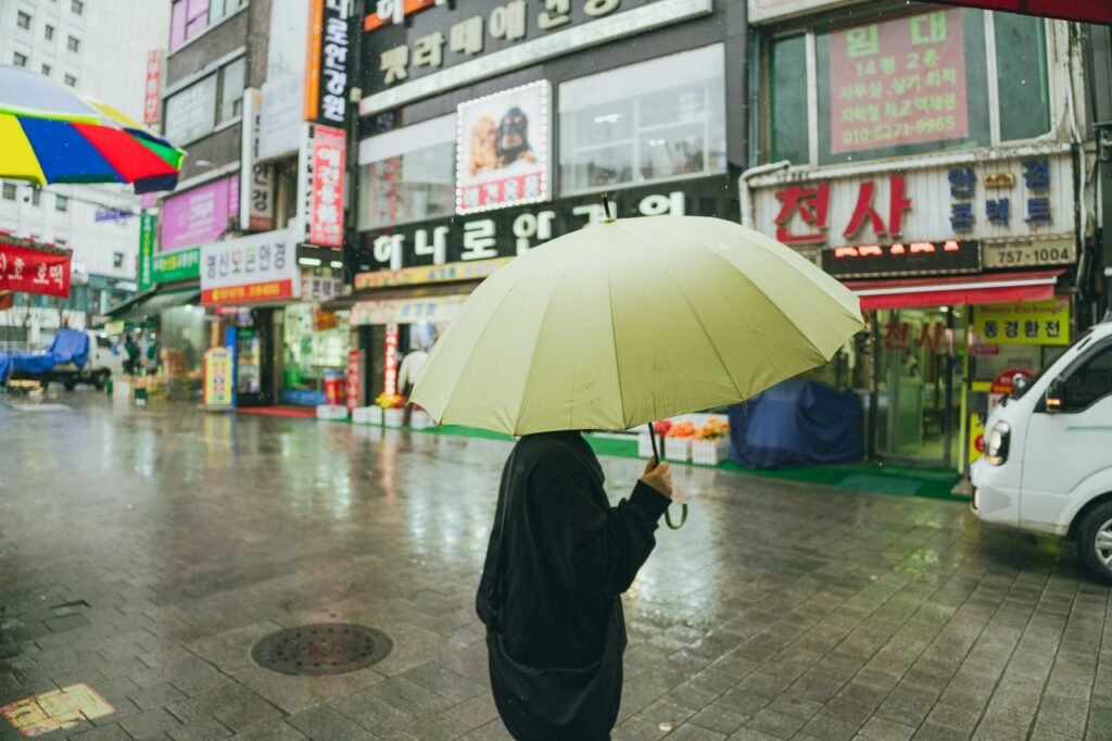 Korea jangma season tips for tourists Seoul rainy street umbrella 2026