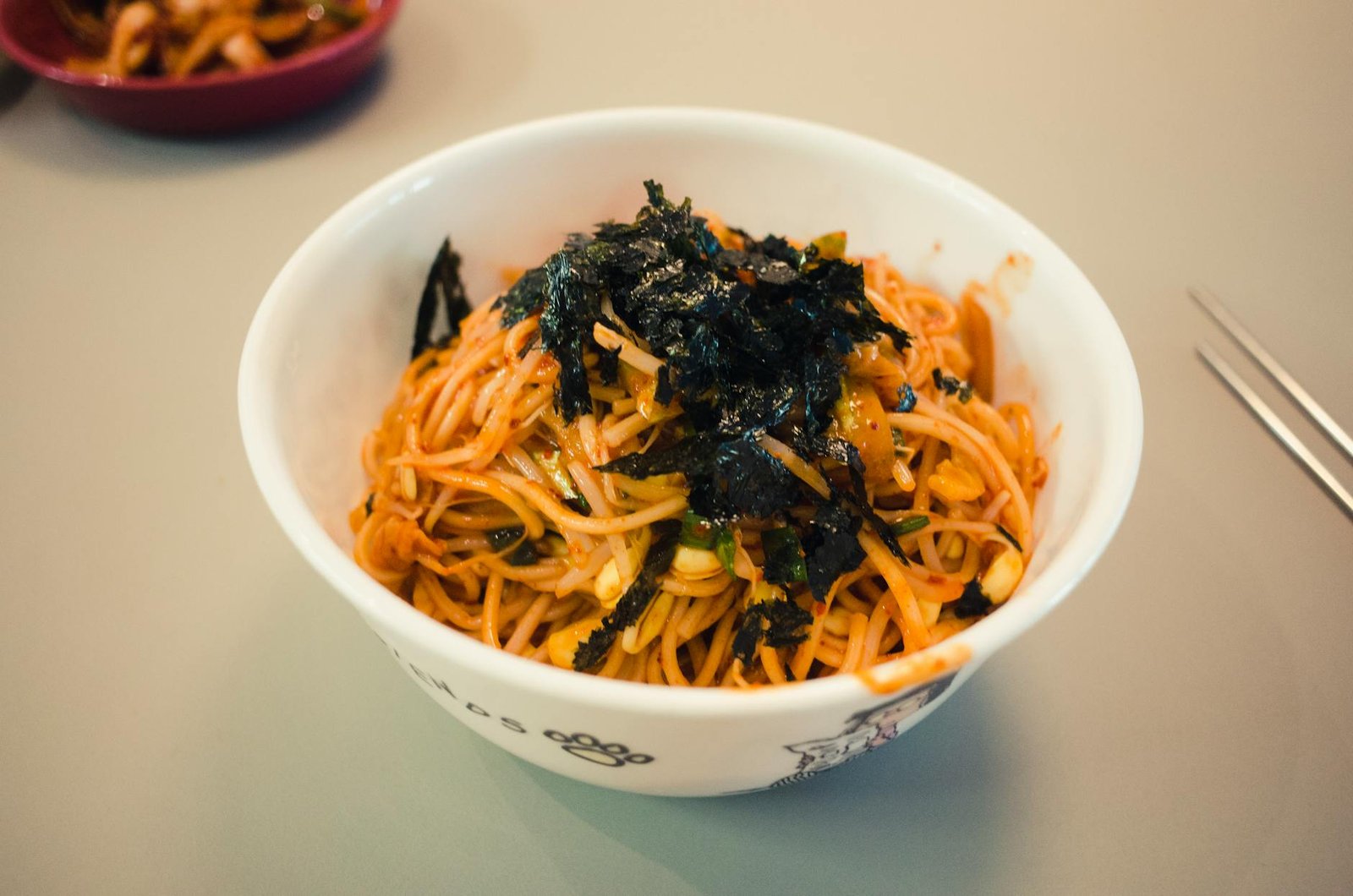 how to eat naengmyeon in Seoul — a bowl of mul naengmyeon with clear cold broth, buckwheat noodles, sliced beef, and cucumber